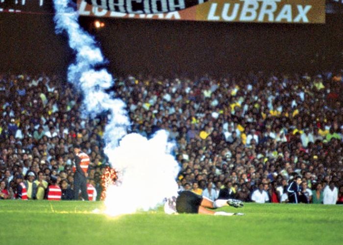 Roberto Rojas sobre el verde de Maracaná y una bengala a su lado, 1989 (Foto de Carta Abierta CL)